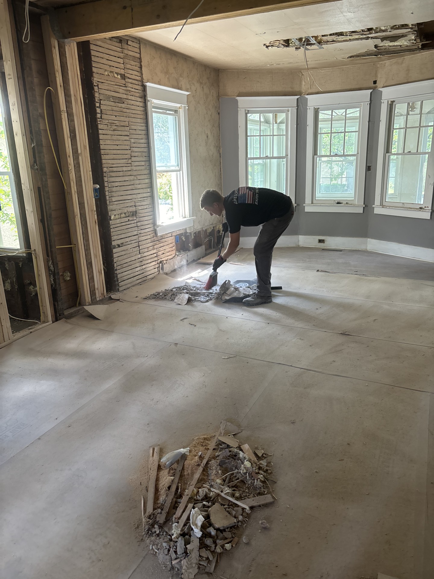 Freedom Hauling crew member sweeping up drywall and debris during an interior demolition