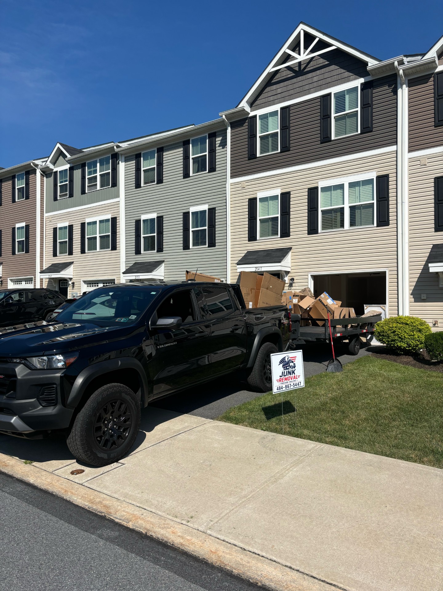 Freedom Hauling truck and trailer loaded with boxes at a townhome job